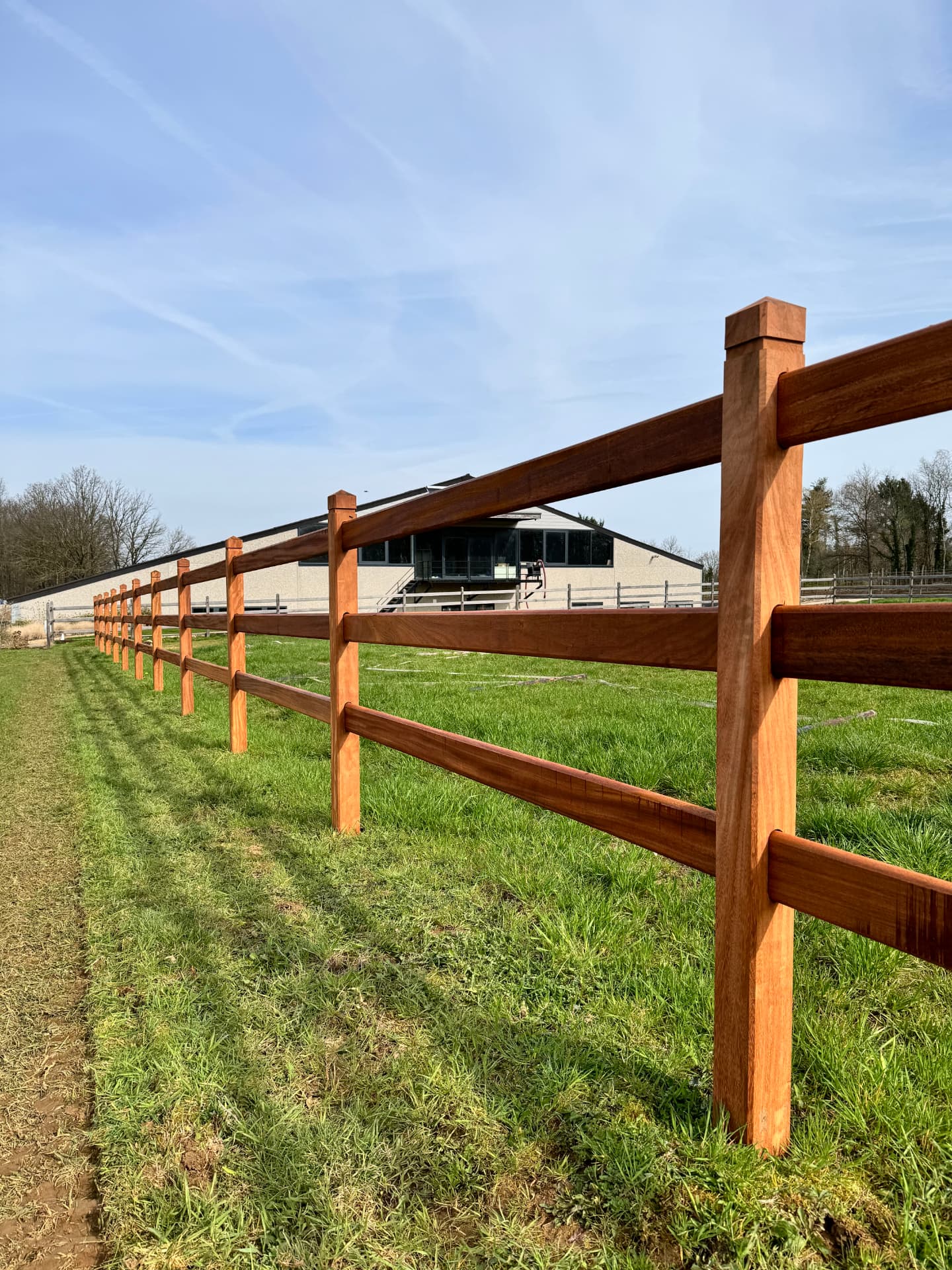 Finish-omheining met drie liggers in perspectief langs een groen perceel
