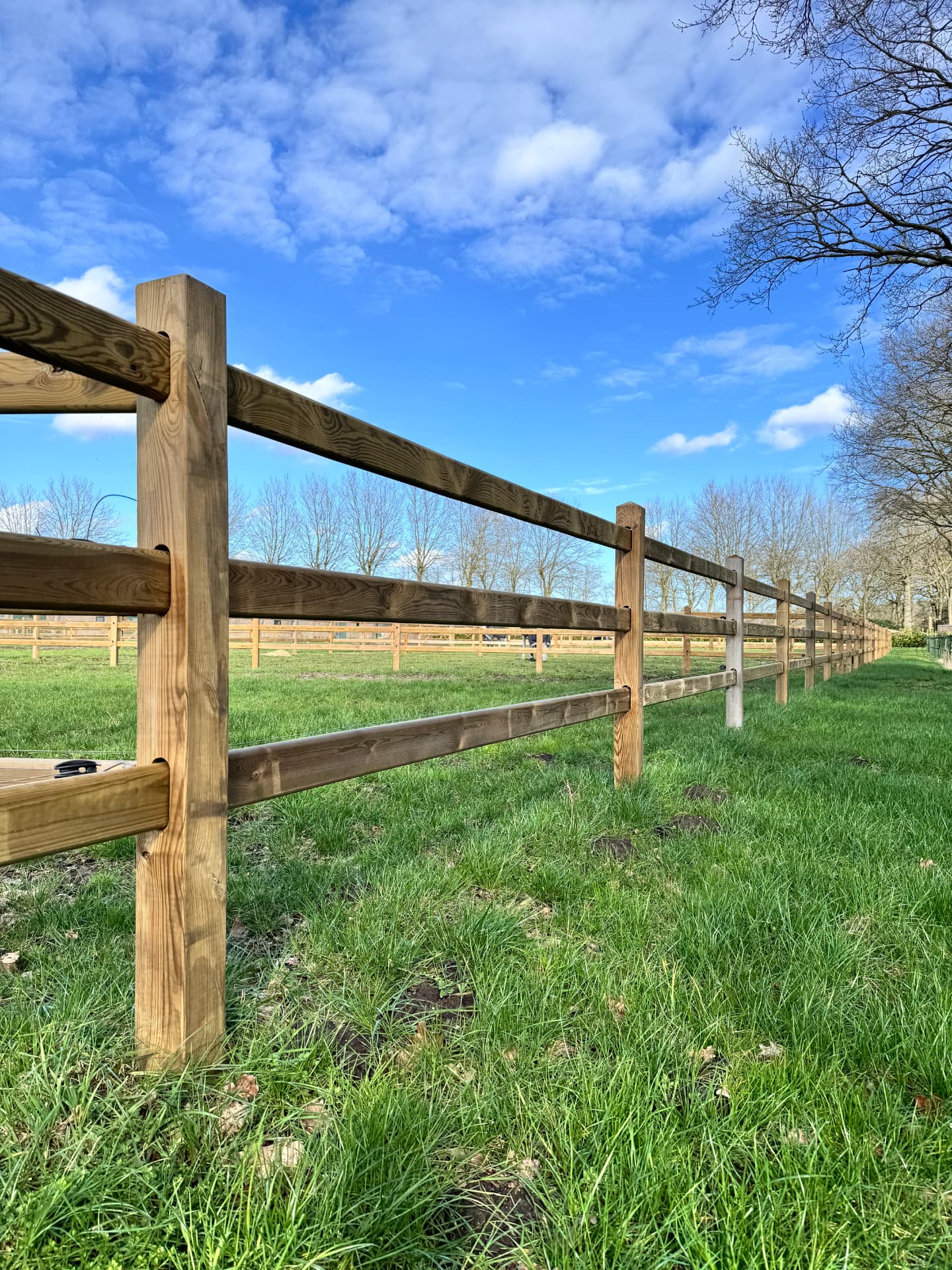 Enjoy-omheining in een groen weiland, gefotografeerd langs de omheiningslijn